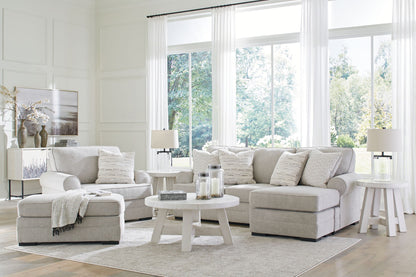 Light gray sofa set in a bright living room with large windows.